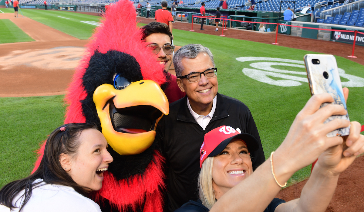 President Kilpatrick poses for a selfie with the cardinal mascot at nationals field