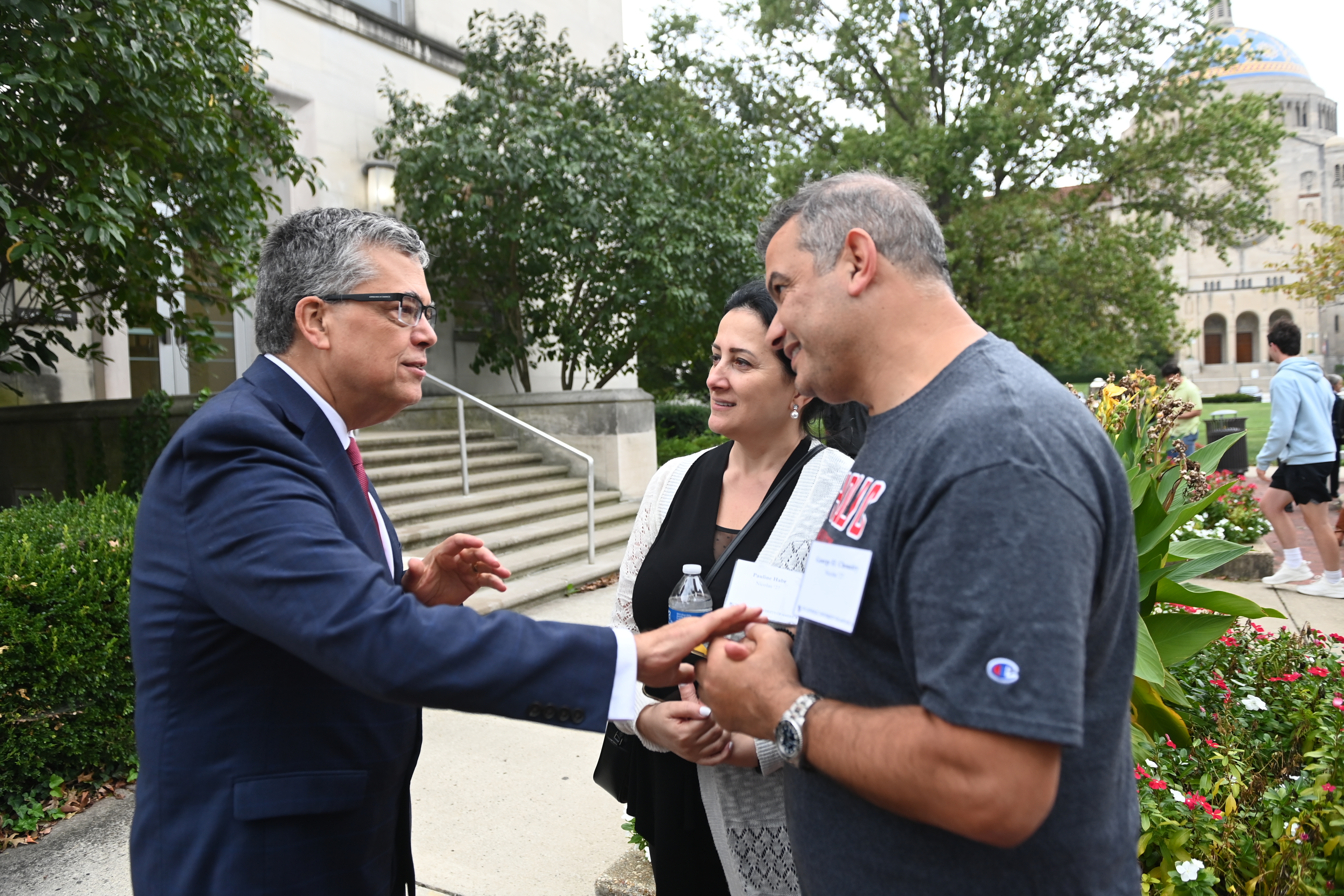 Peter Kilpatrick speaks with two Catholic University parents during Family Weekend.