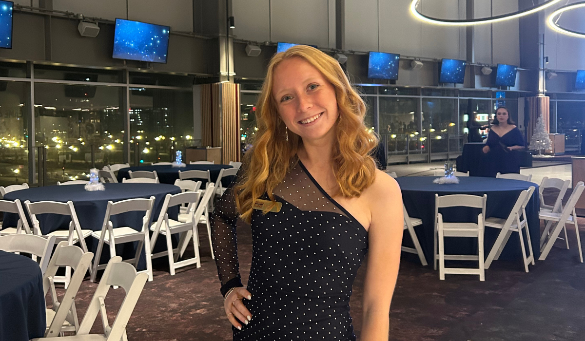 Lindsey is wearing a formal blue dress at an event.