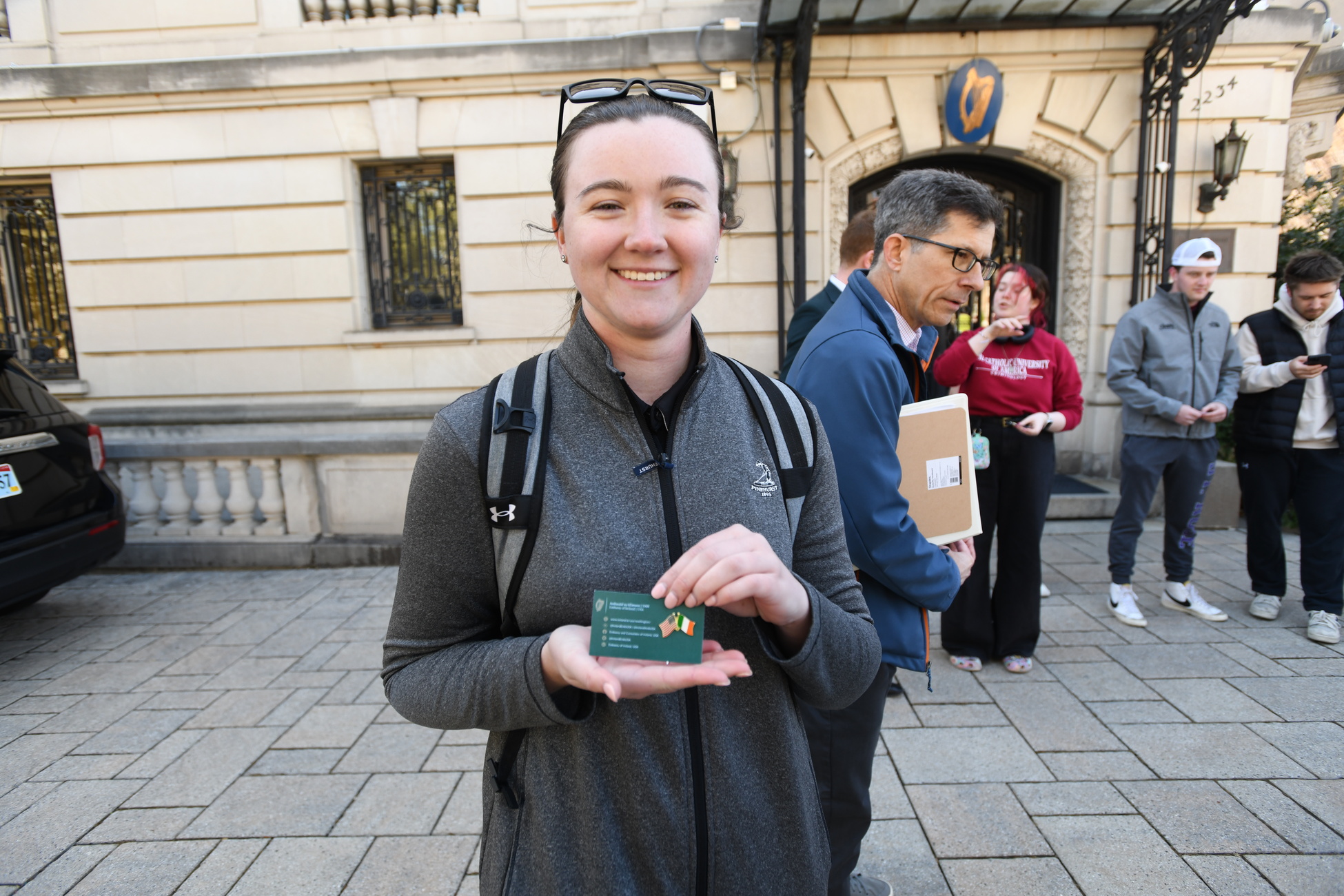 A student holds a commemorative pin from a visit to the Embassy of Ireland