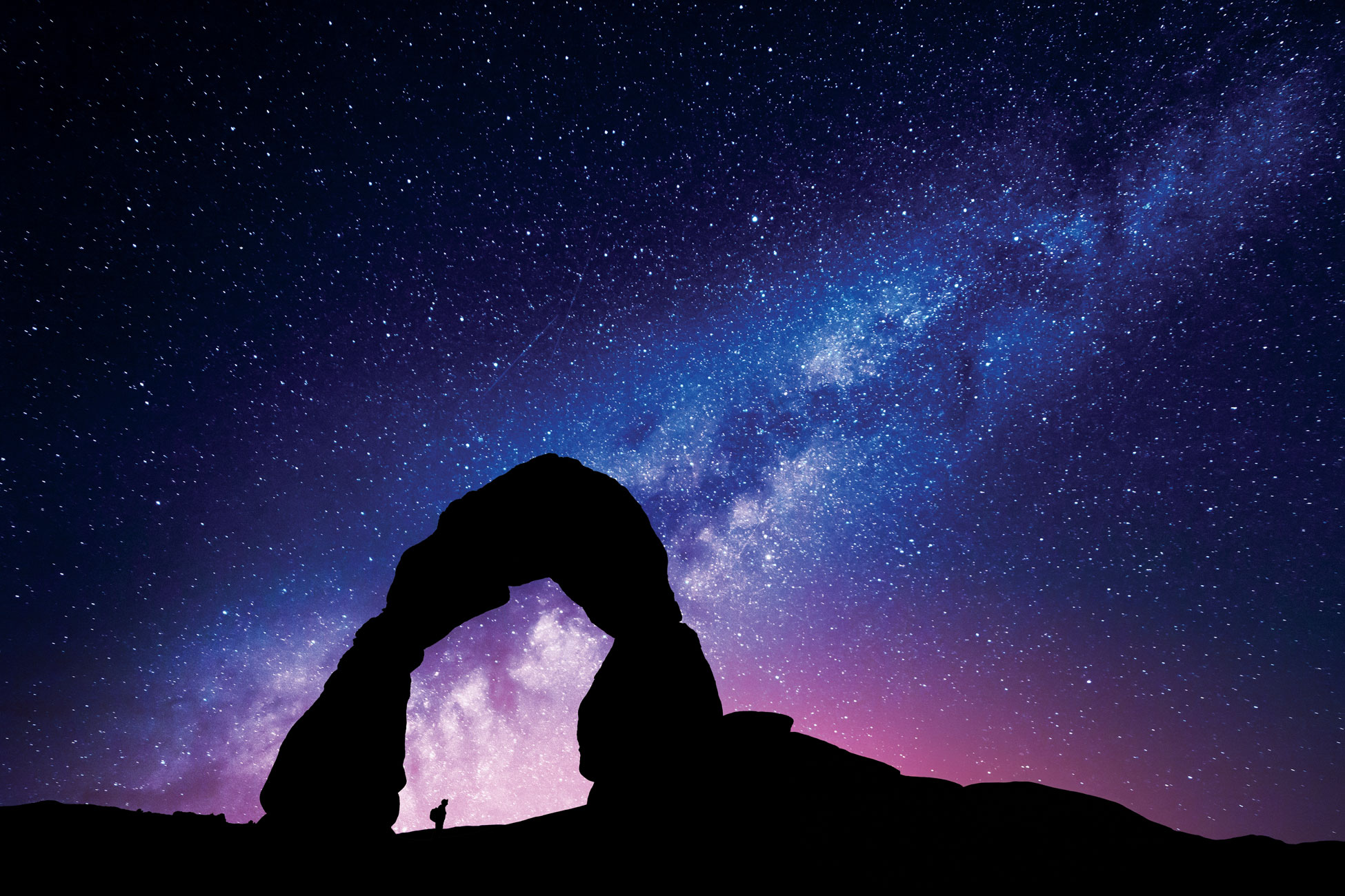 An explorer looking up at a starry sky.