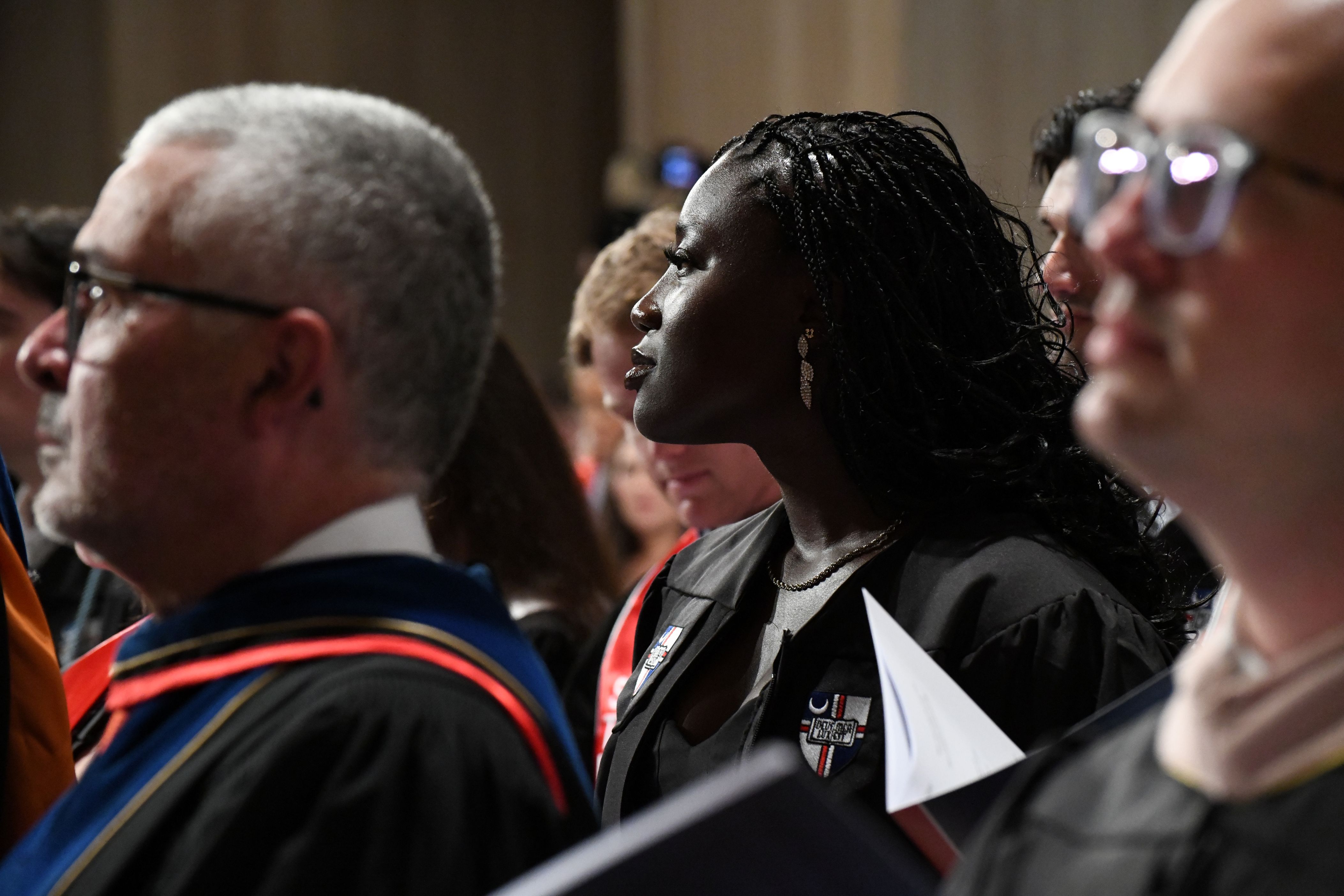Female graduate praying at Mass