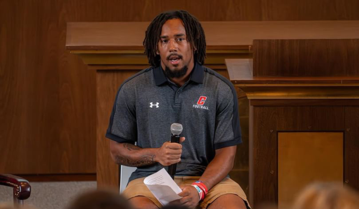 Malachi is speaking in Heritage Hall, wearing a Cardinals Football polo.