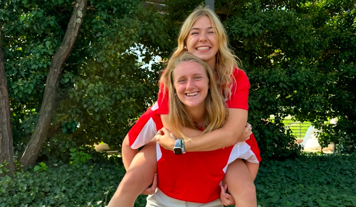 Catherine is receiving a piggyback from a fellow Orientation Leader.
