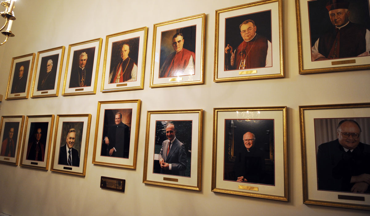 A wall of photos of past presidents of CUA
