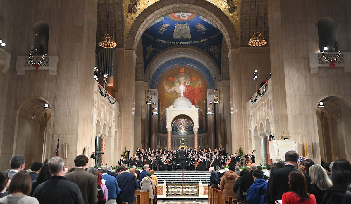 Christmas in the Basilica of the National Shrine of the Immaculate Conception, featuring filled pews and a choir at the altar. 