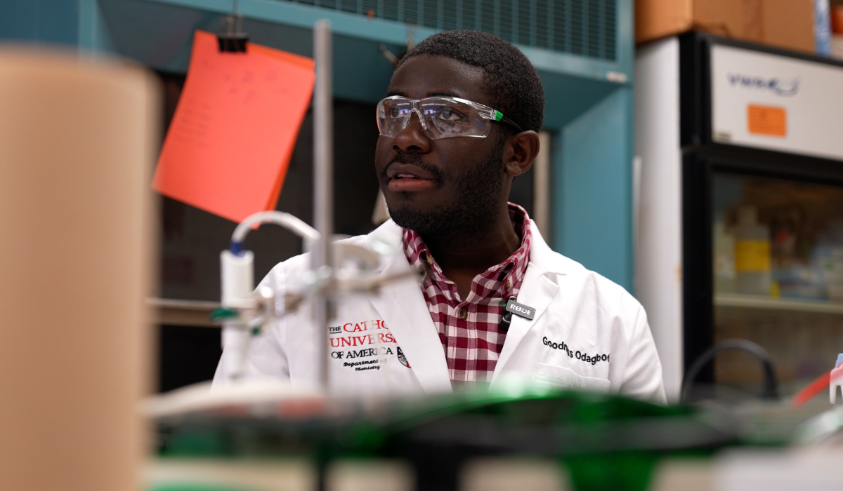 Goodness Odagbodo in the lab, wearing a white lab coat and goggles.