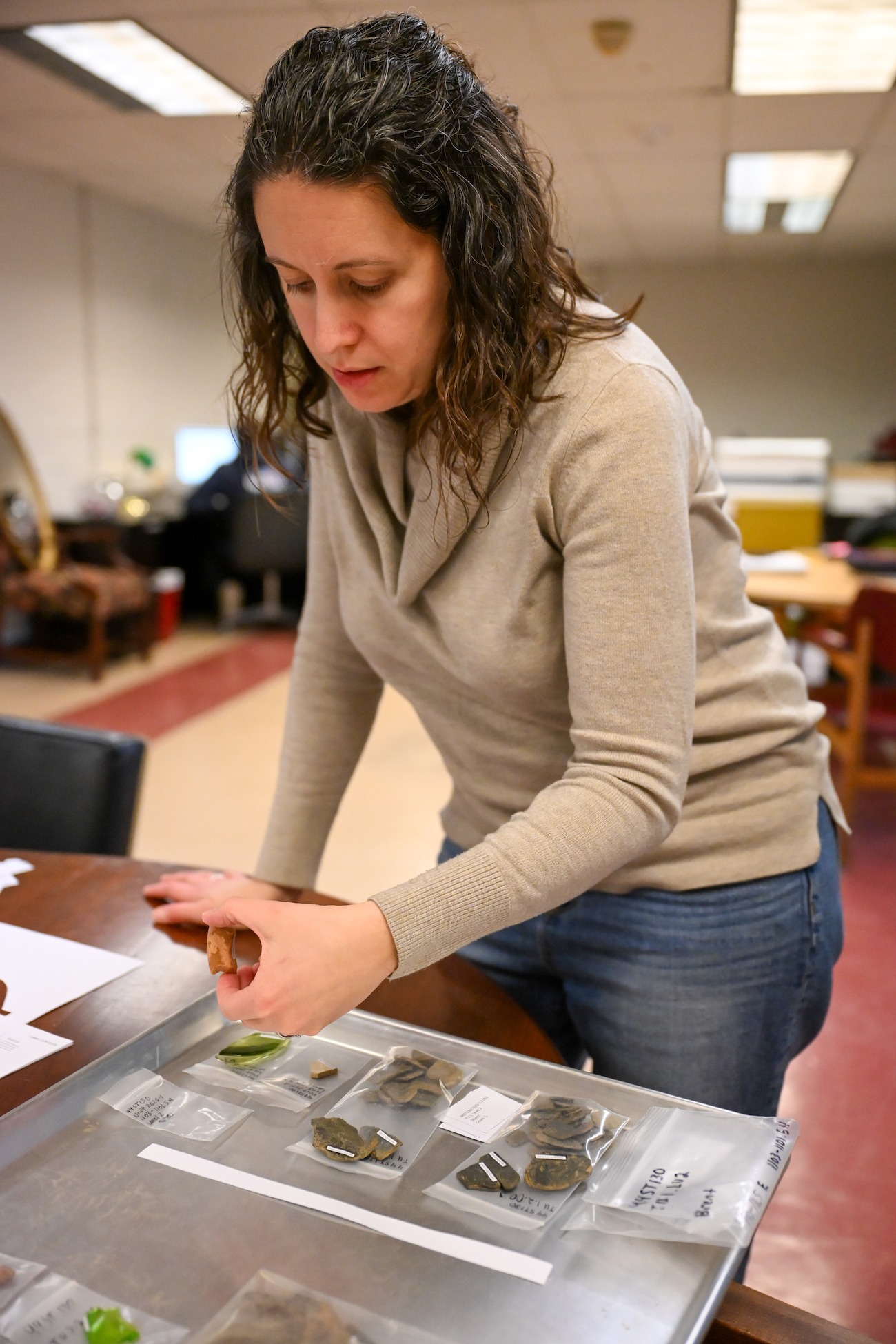 Laura Masur, assistant professor of anthropology, examines an artifact from the Brent Family Cemetery in Aquia at The Catholic University of America in Washington Feb. 6. Photo by Anna Dinofrio