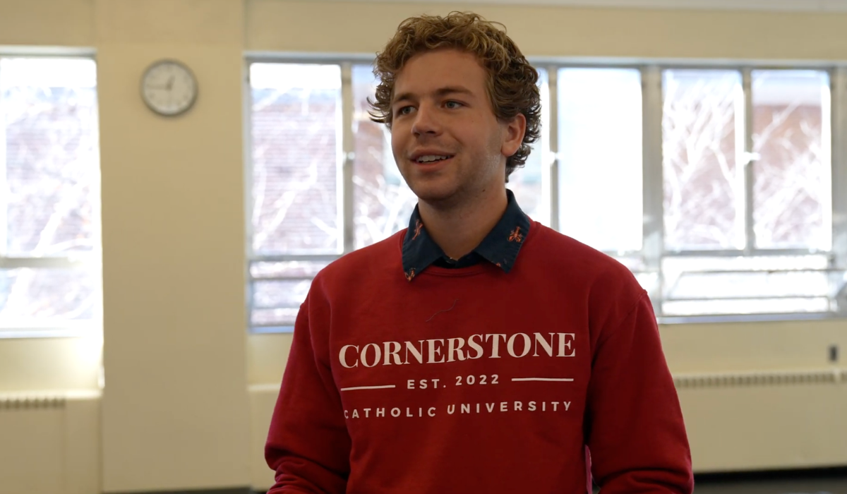 Anthony Graf in a classroom at Catholic University, wearing a Cornerstone sweatshirt.
