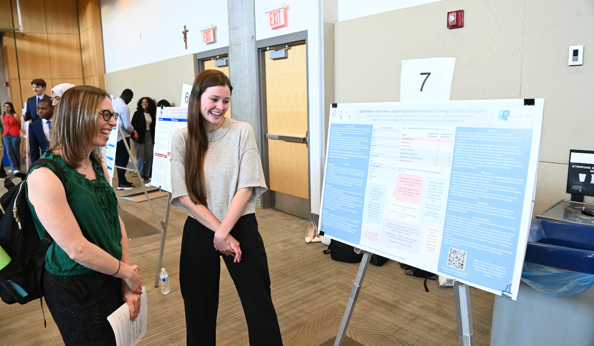 Two students are chatting over a poster presentation at URD2026.