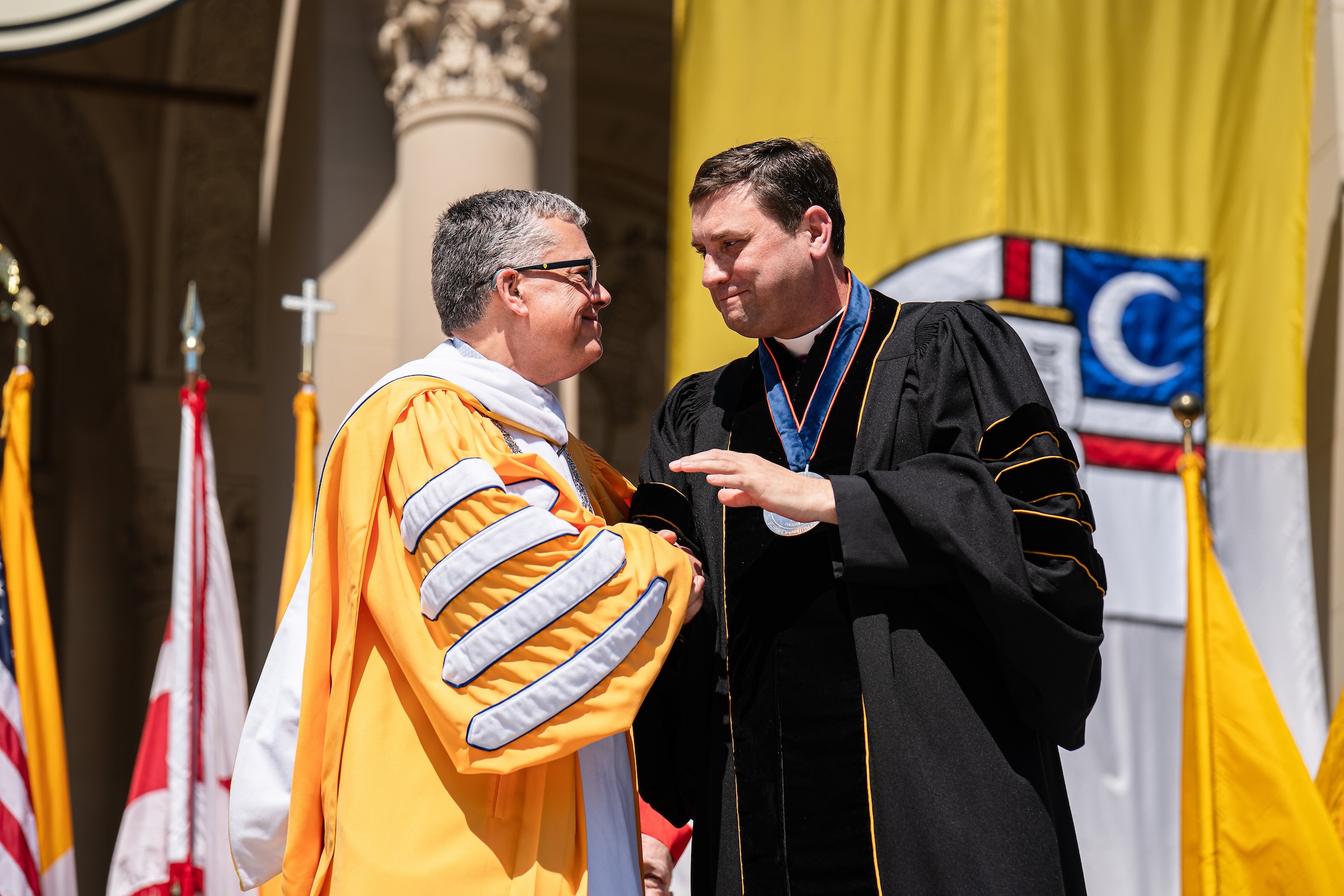 Catholic University President Peter Kilpatrick congratulates Msgr. James Shea on the latter's honorary doctorate.