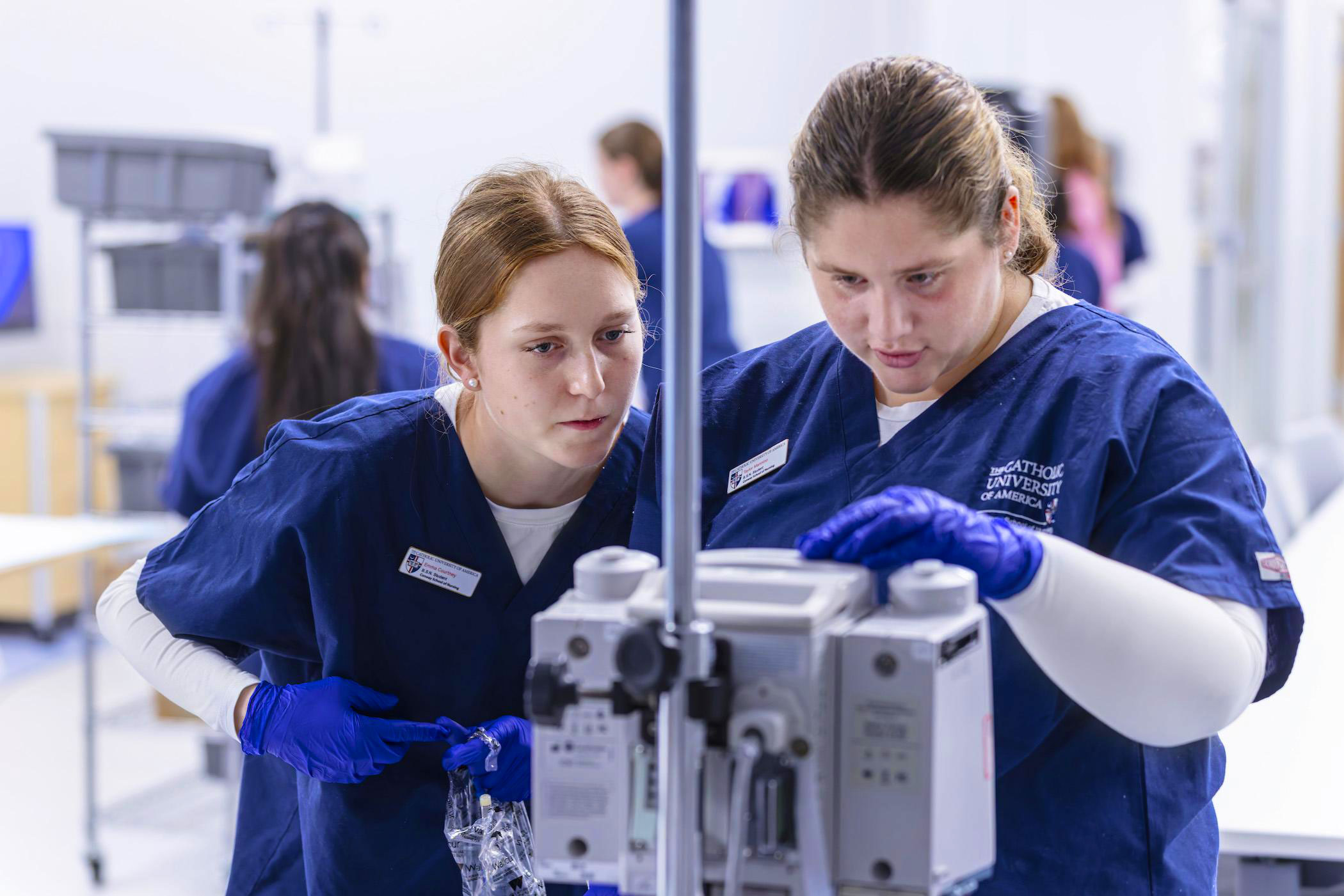 Nursing students using lab equipment in a simulation lab.