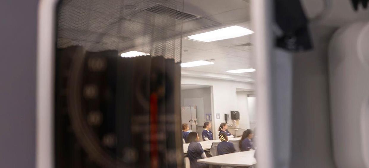 reflection of a nursing training off of medical equipment