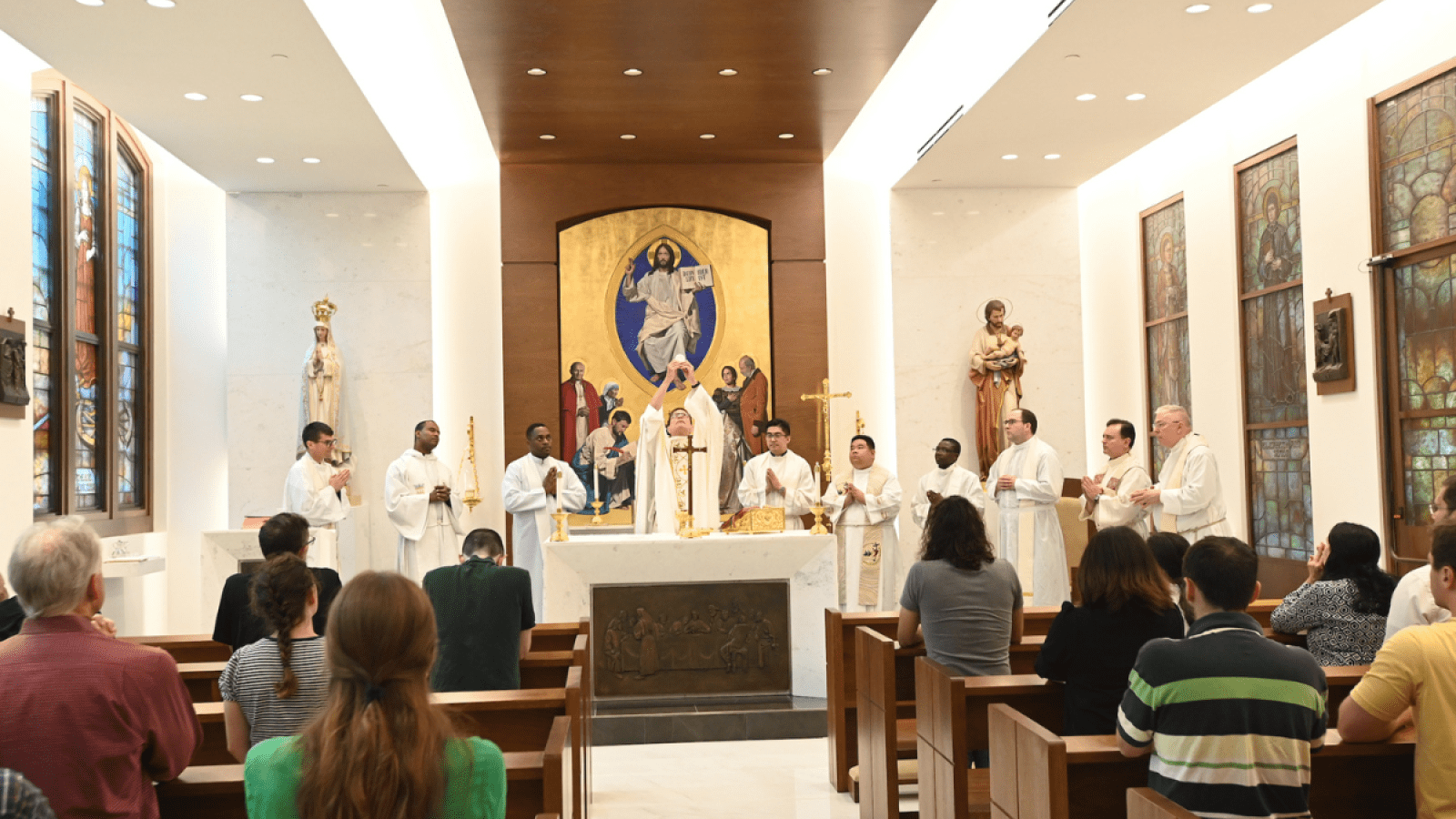 priests concelebrating at mass in the St. Michael chapel in the business school