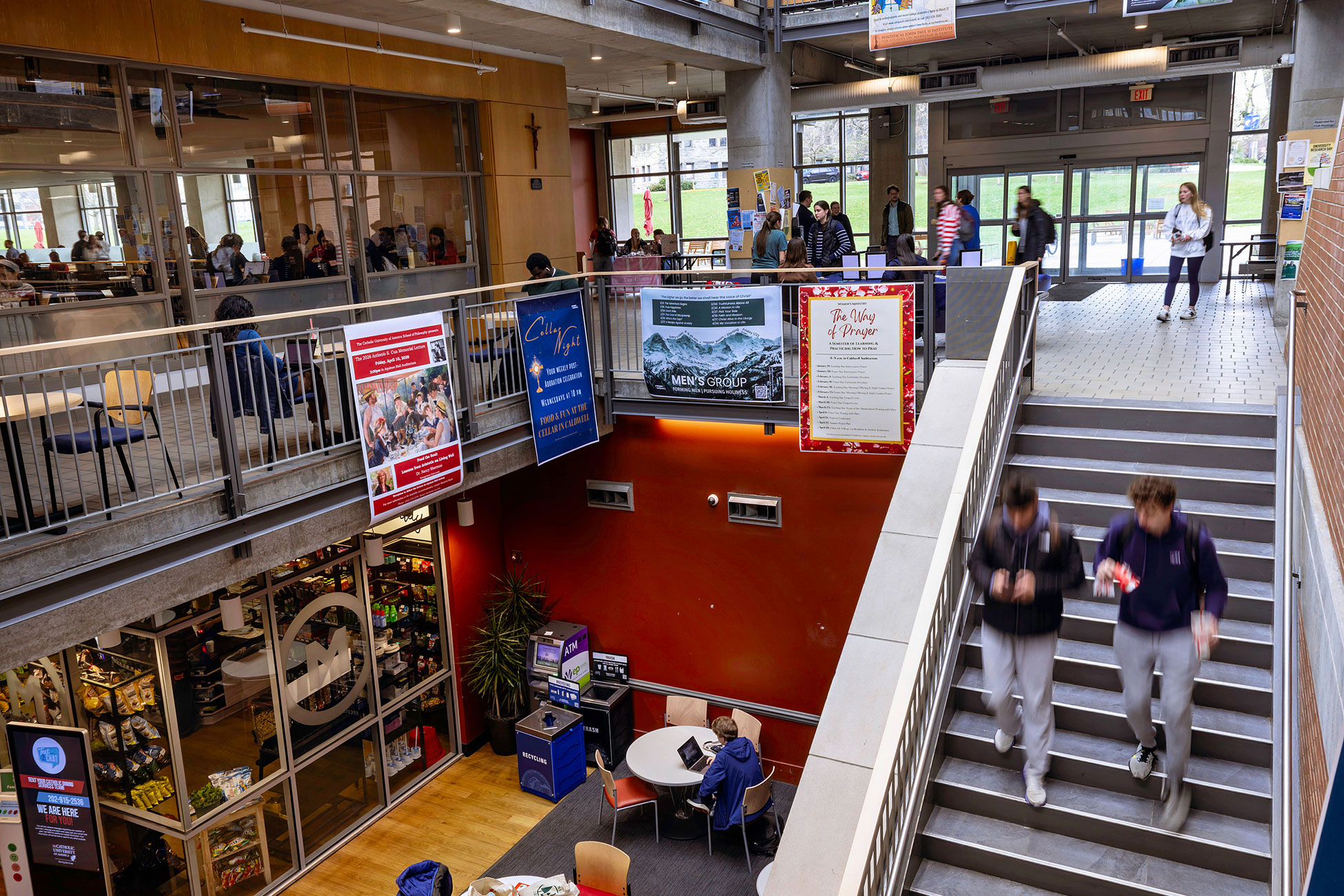 Students and banners in the central corridor of the Pryz student center.