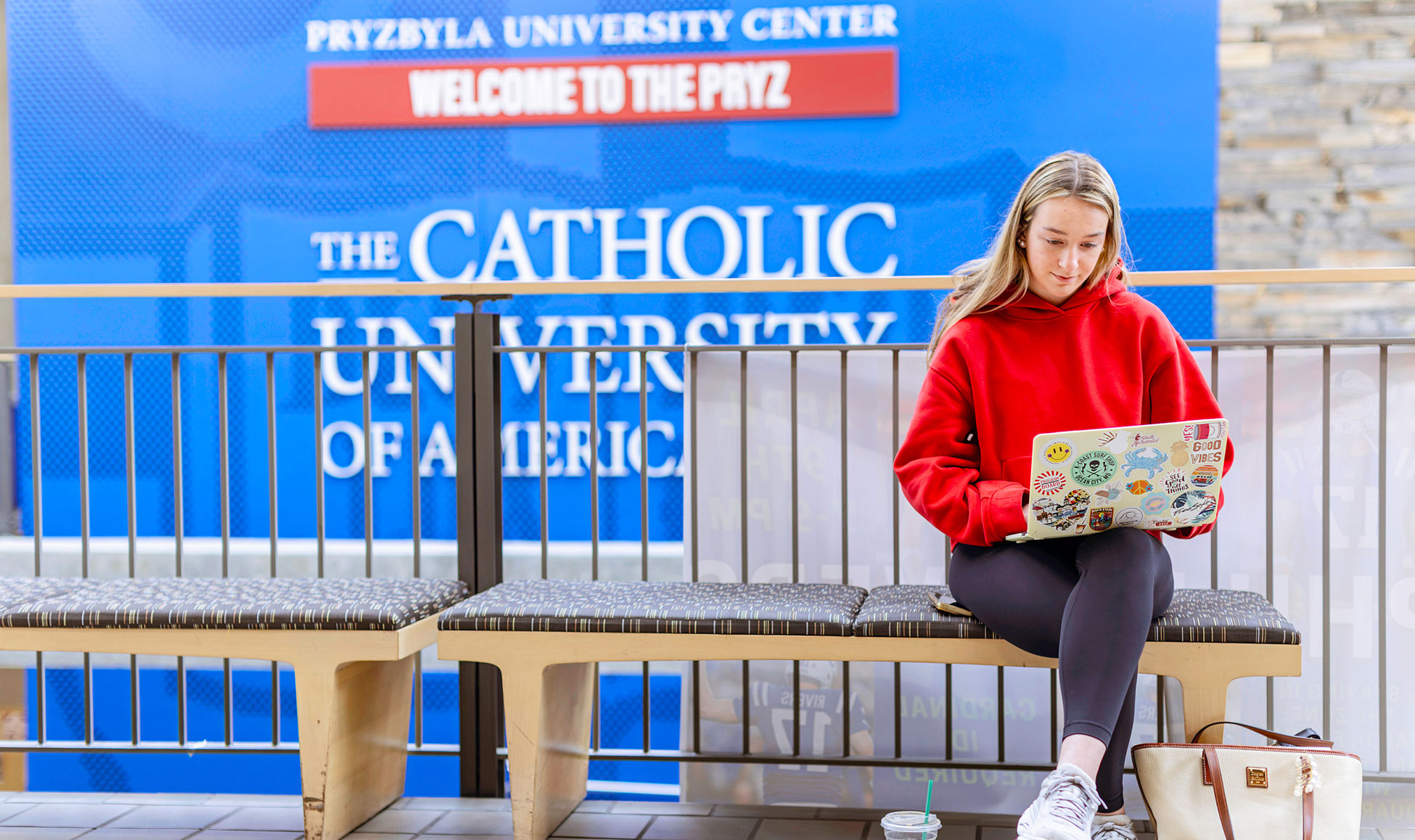 Female students sitting in the Pryz studying on a laptop.