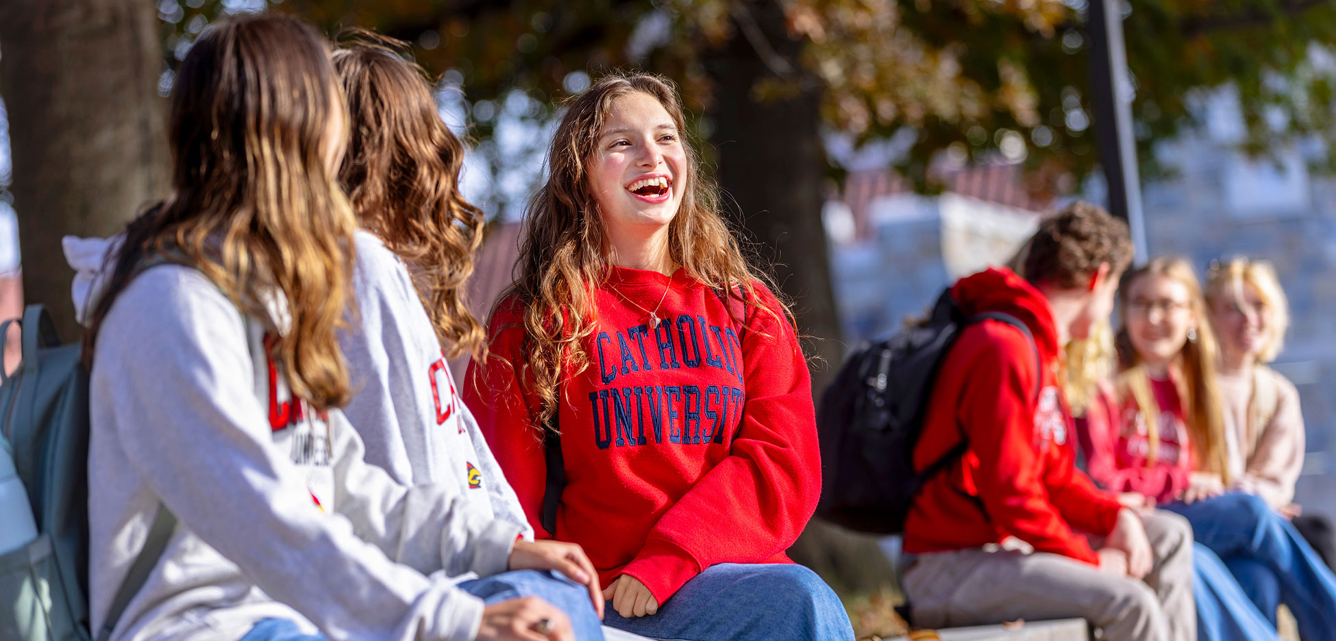 Catholic University students talking outdoors on campus.