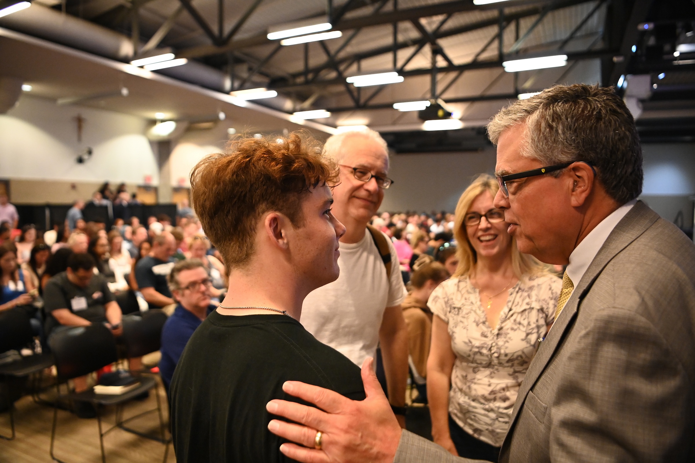 Peter Kilpatrick speaks to a new student and his two parents.