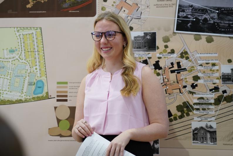 Student standing in front of drawings