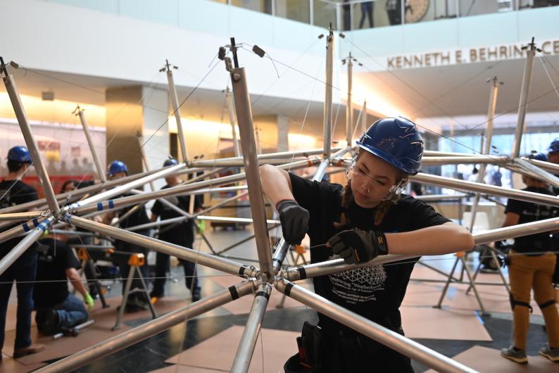 Student assembling a geodesic dome at smithsonian day