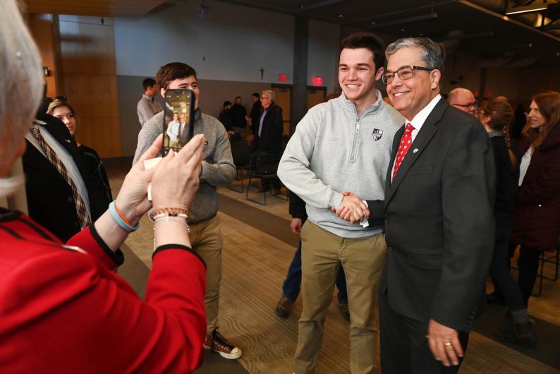 student shaking president Kilpatrick's hand