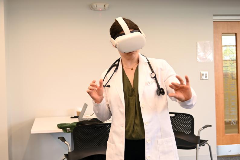 A nursing student uses a headset during a demo for an immersive simulation of a lumbar puncture procedure.