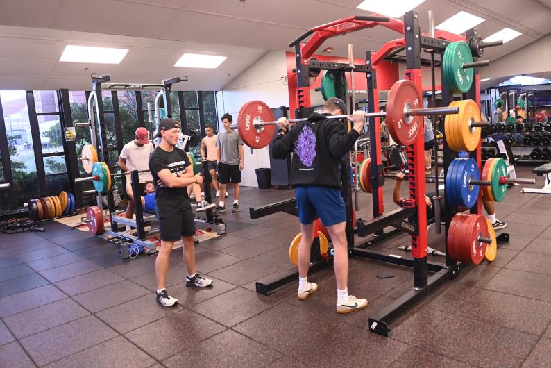 students lifting weights in the Kane Fitness Center