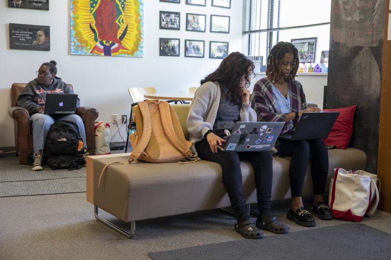 students collaborate on a laptop together