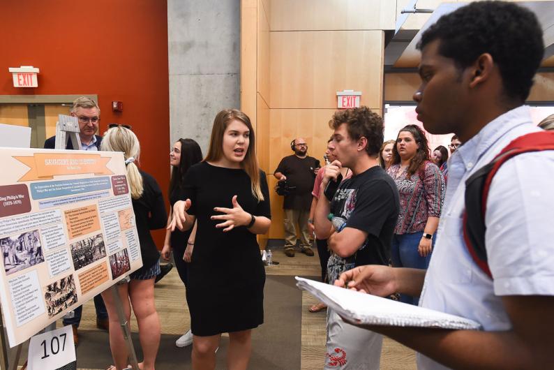 student explaining her research project at university research day