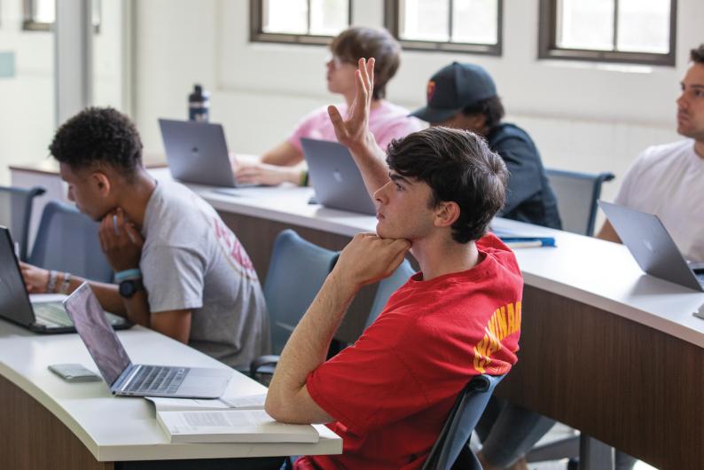 student raising his hand in class