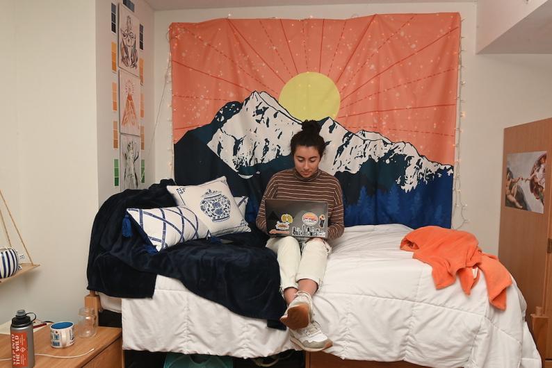 student working on her laptop in her dorm