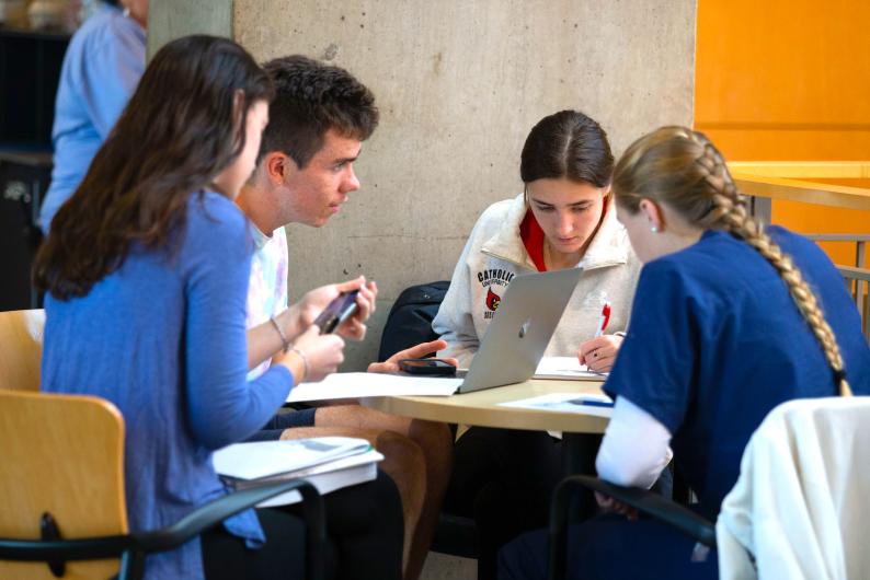 students working on schoolwork together at a round table