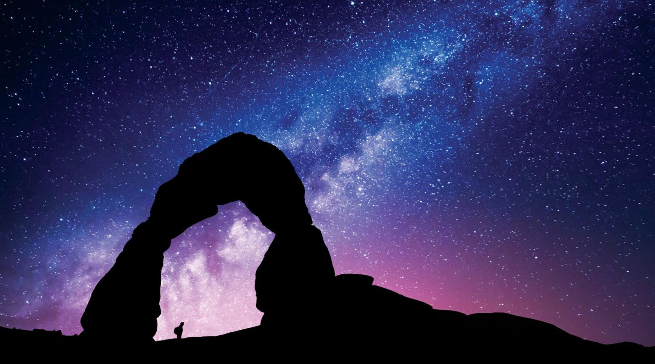 An explorer looking up at a starry sky.