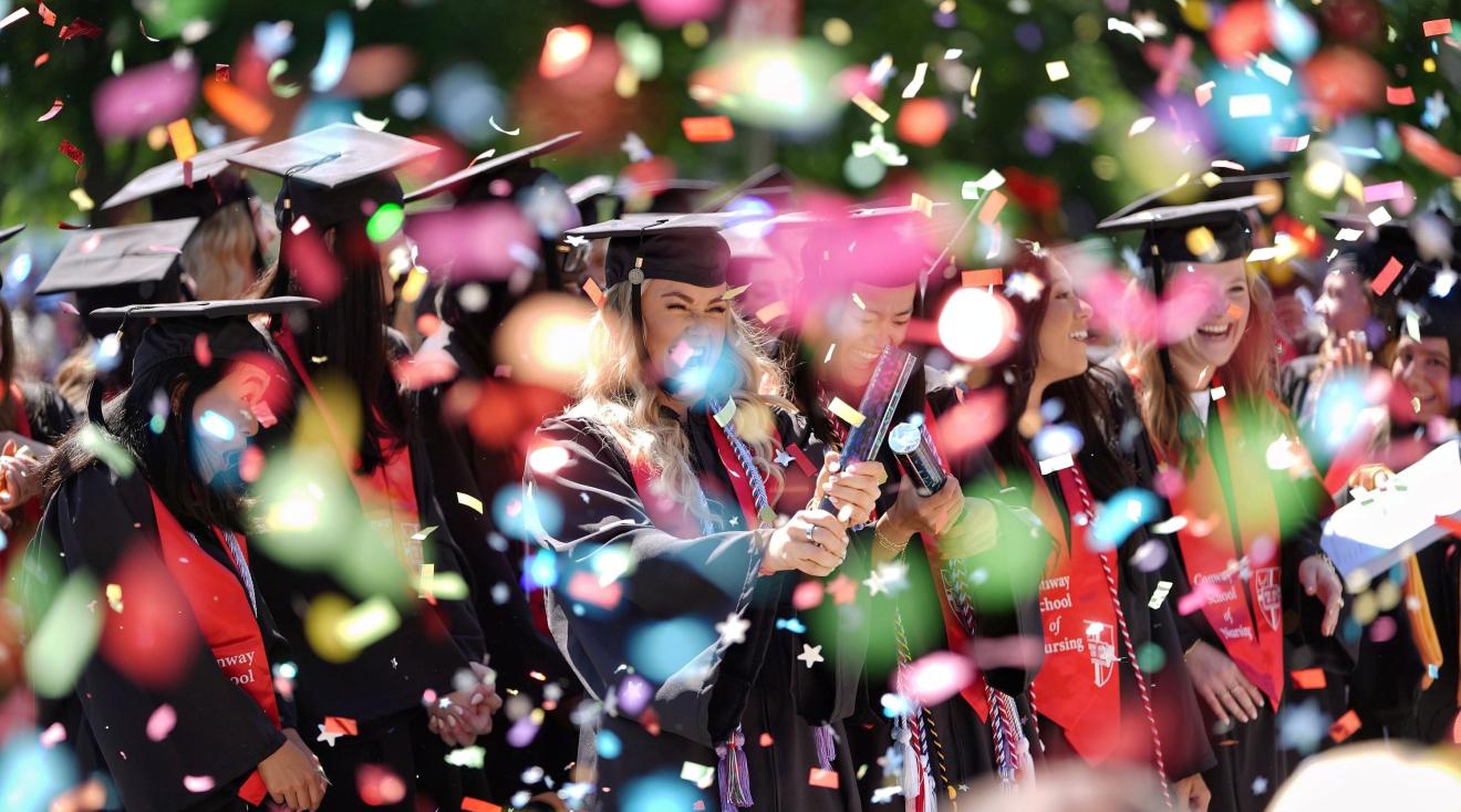 Catholic University graduates celebrate with confetti.