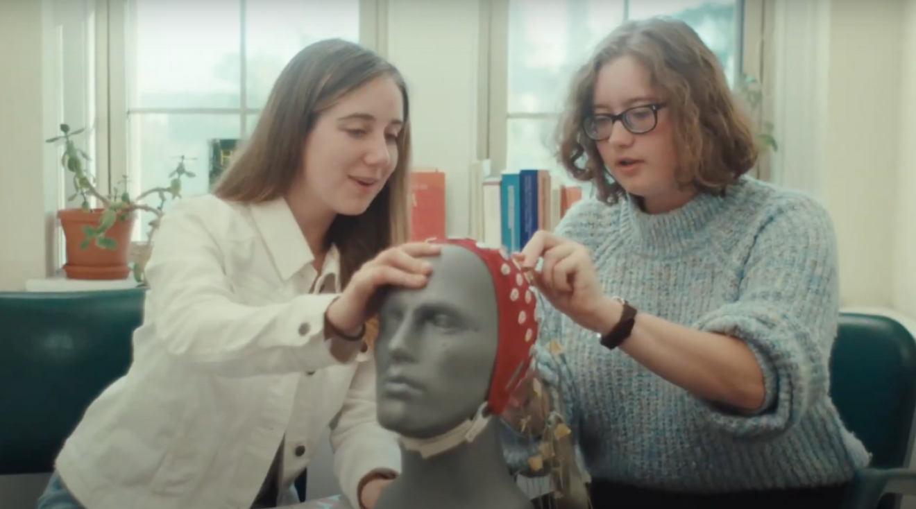 Two students are examining a model head in a psychology class.