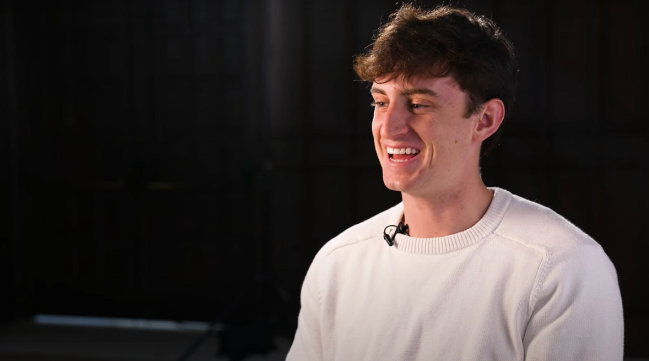 Owen Moynihan's video thumbnail, featuring him sitting in Heritage Hall.